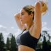 A focused woman in sportswear tying her hair, preparing for an outdoor workout in Mexico City.