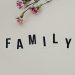 Elegant arrangement of pink flowers and family text on a white background, ideal for family themes.